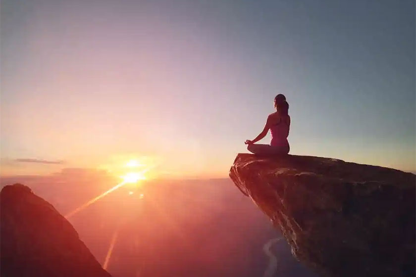 Foto de uma mulher admirando o pôr do sol